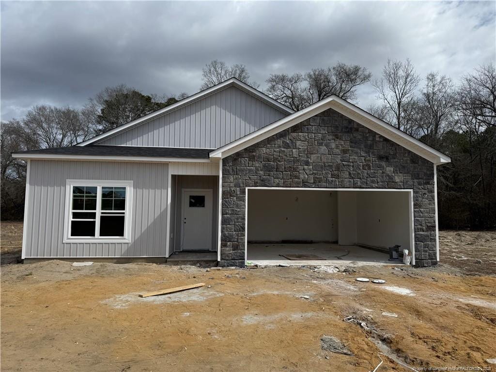 view of front of home featuring a garage and stone siding