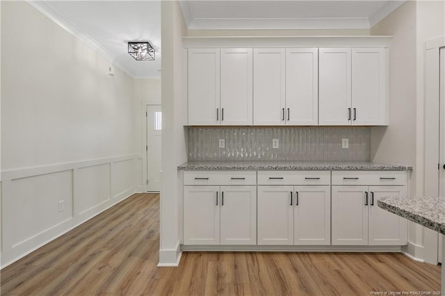 4921 High Branch Ct, Stedman, NC 28391 - kitchen with crown molding, light wood-type flooring, white cabinetry, tasteful backsplash, and light stone counters