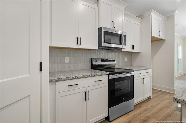 4921 High Branch Ct, Stedman, NC 28391 - kitchen featuring appliances with stainless steel finishes, light stone counters, backsplash, white cabinets, and light wood-style floors