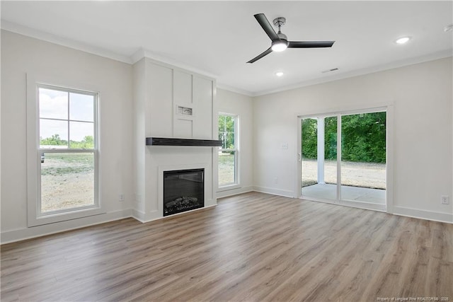 4921 High Branch Ct, Stedman, NC 28391 - unfurnished living room featuring a glass covered fireplace, ceiling fan, light wood-style flooring, and crown molding
