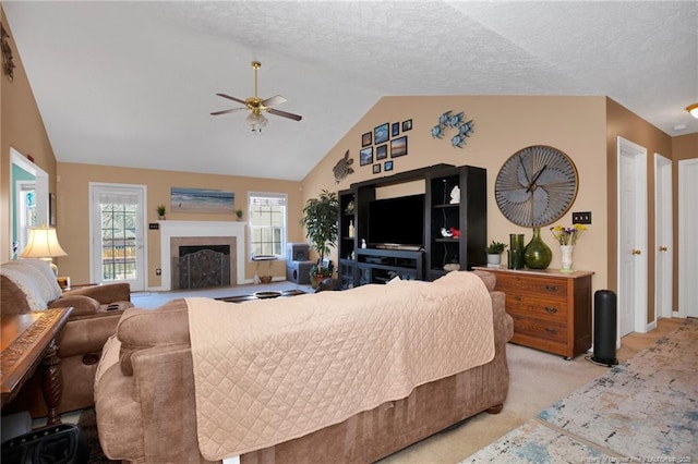 living room with ceiling fan, light colored carpet, lofted ceiling, and a textured ceiling