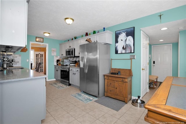 kitchen featuring backsplash, appliances with stainless steel finishes, sink, and white cabinets