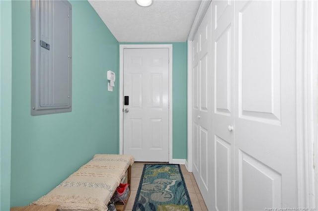 entryway featuring light tile patterned flooring, electric panel, and a textured ceiling