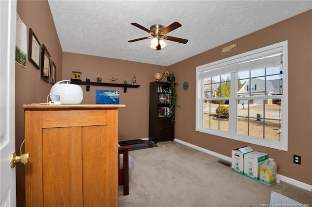 misc room with ceiling fan, light carpet, and a textured ceiling