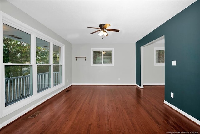 unfurnished room with ceiling fan and dark hardwood / wood-style flooring