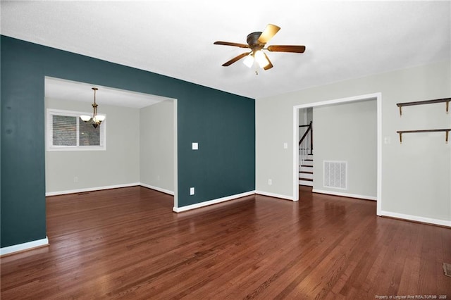 unfurnished living room with dark wood-type flooring and ceiling fan with notable chandelier