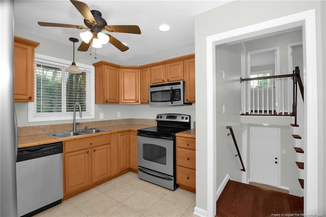 kitchen featuring sink, light tile patterned floors, ceiling fan, stainless steel appliances, and decorative light fixtures