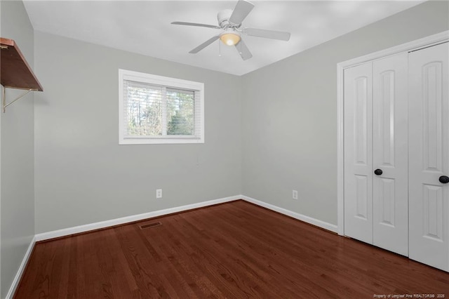 unfurnished bedroom featuring ceiling fan, dark hardwood / wood-style floors, and a closet