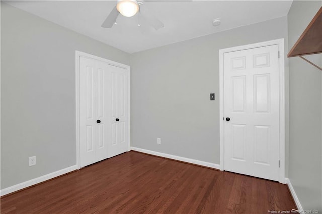 unfurnished bedroom featuring dark wood-type flooring, a closet, and ceiling fan