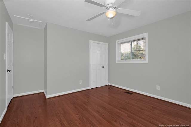 unfurnished bedroom featuring a closet, dark hardwood / wood-style floors, and ceiling fan