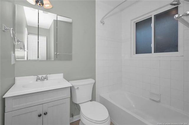 full bathroom with tiled shower / bath, vanity, and toilet