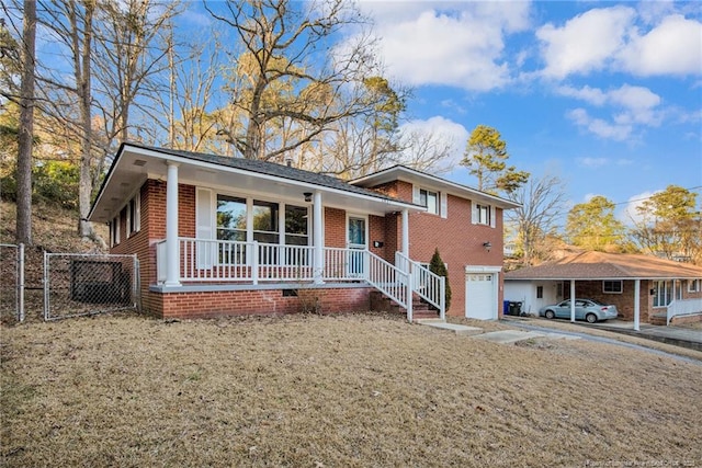 tri-level home featuring a garage, covered porch, and a front lawn