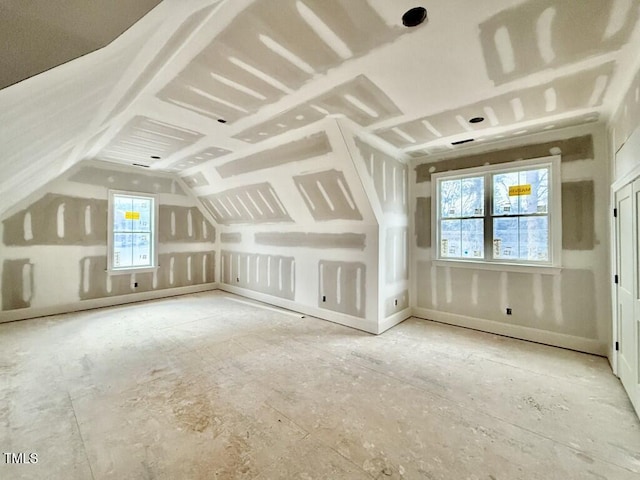 additional living space featuring lofted ceiling