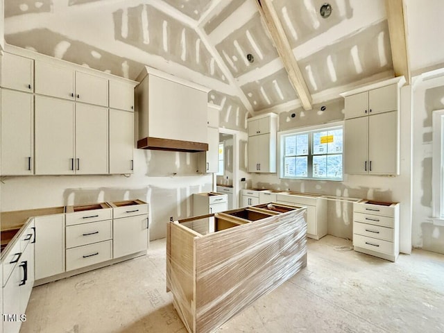 kitchen featuring white cabinetry and lofted ceiling