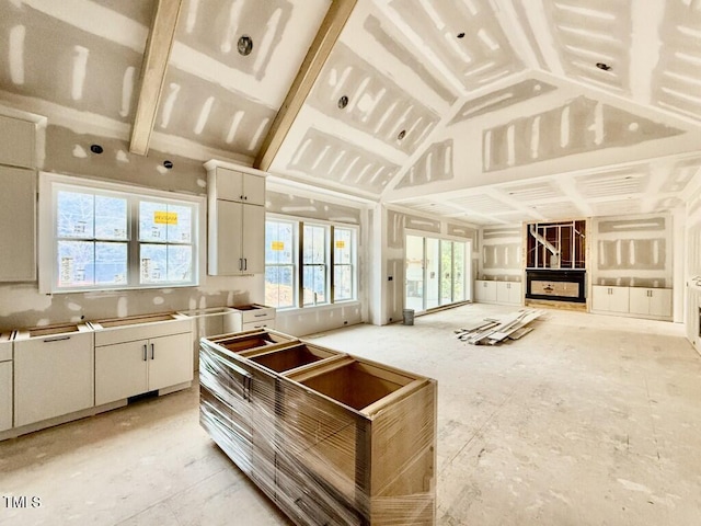 kitchen featuring vaulted ceiling and white cabinets