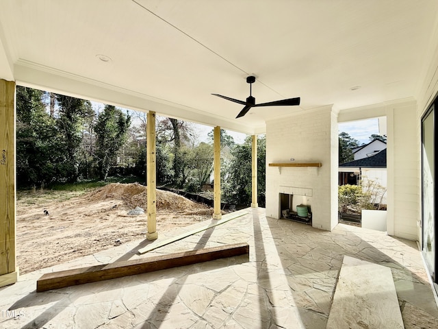 unfurnished sunroom with exterior fireplace and a ceiling fan