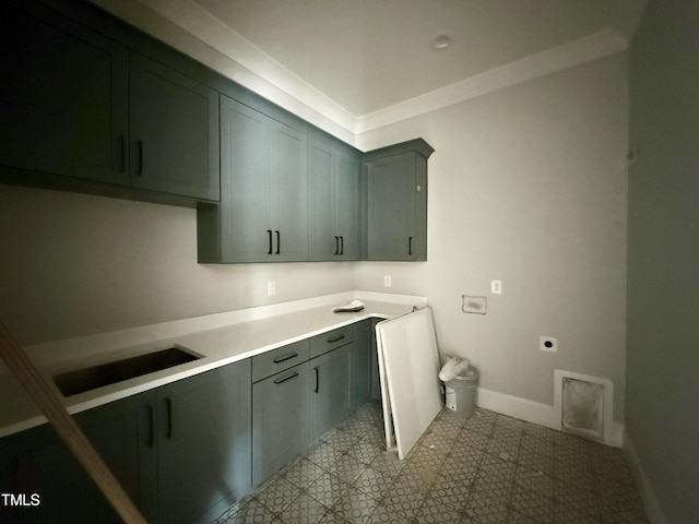 clothes washing area featuring cabinet space, baseboards, hookup for an electric dryer, and a sink