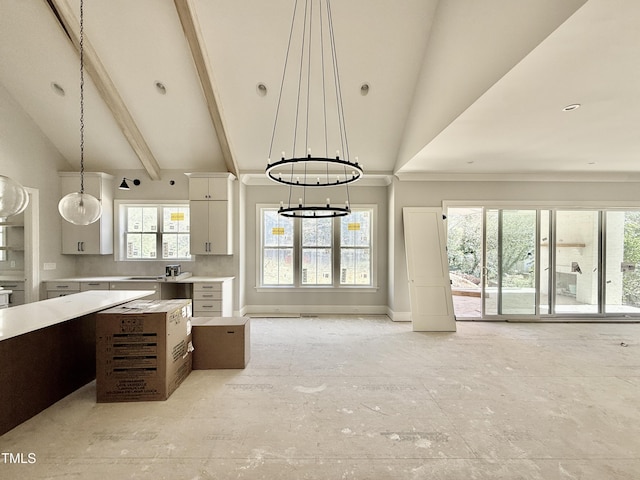 kitchen featuring baseboards, light countertops, pendant lighting, white cabinetry, and a notable chandelier