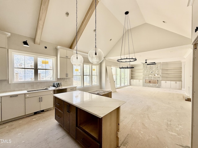 kitchen with high vaulted ceiling, decorative light fixtures, tasteful backsplash, a kitchen island, and open floor plan