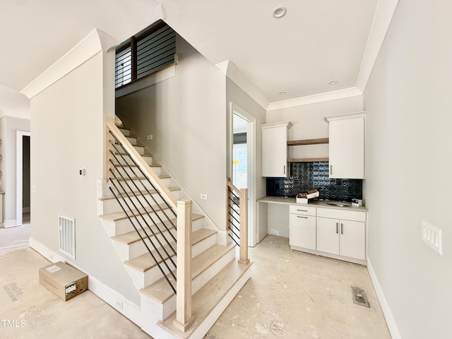 staircase featuring crown molding, baseboards, and visible vents