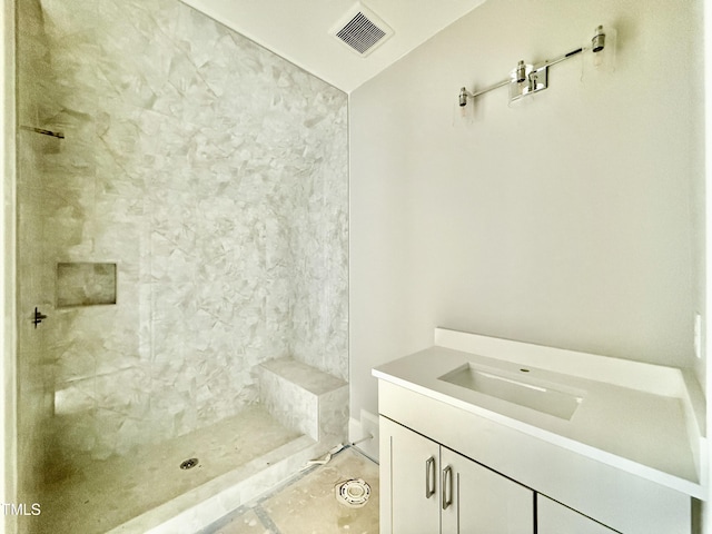 bathroom featuring vanity, visible vents, and tiled shower