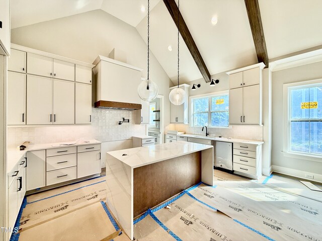 kitchen featuring dishwasher, backsplash, hanging light fixtures, and a sink