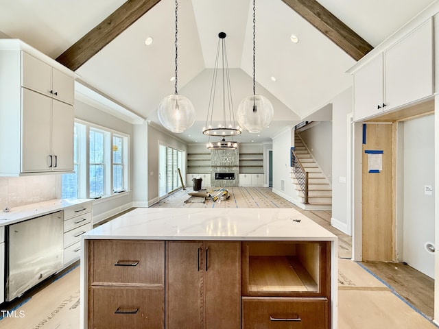 kitchen with high vaulted ceiling, decorative backsplash, decorative light fixtures, white cabinets, and light stone countertops