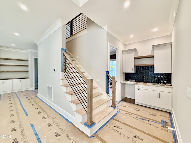 interior space featuring recessed lighting, backsplash, visible vents, crown molding, and baseboards