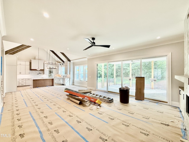 living room with recessed lighting, vaulted ceiling with beams, a ceiling fan, crown molding, and baseboards
