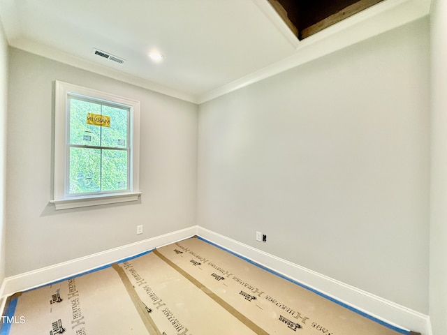 unfurnished room with baseboards, crown molding, and visible vents