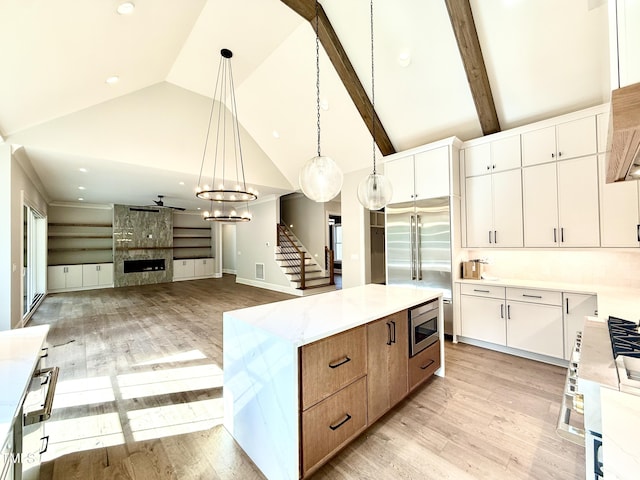 5820 Shawood Dr, Raleigh, NC 27609 - kitchen with a center island, light wood finished floors, light countertops, white cabinets, and high vaulted ceiling