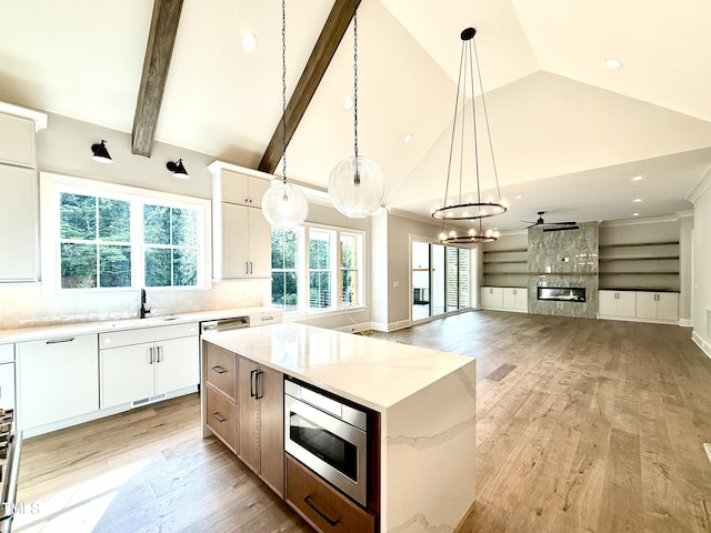 5820 Shawood Dr, Raleigh, NC 27609 - kitchen with stainless steel appliances, a large fireplace, light wood-style floors, a sink, and a center island