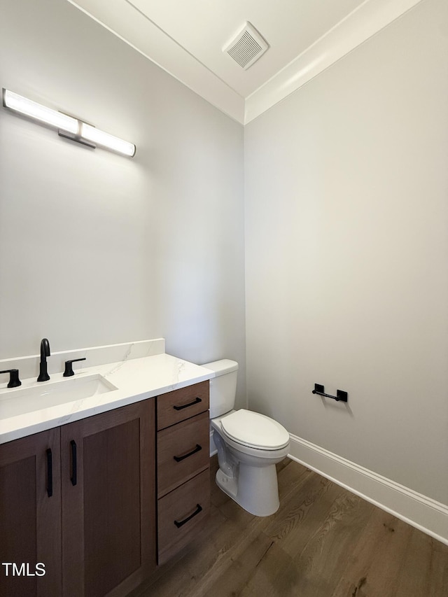 5820 Shawood Dr, Raleigh, NC 27609 - half bath featuring wood finished floors, toilet, vanity, and baseboards