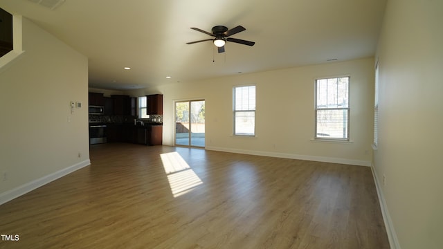 unfurnished living room featuring hardwood / wood-style floors and ceiling fan