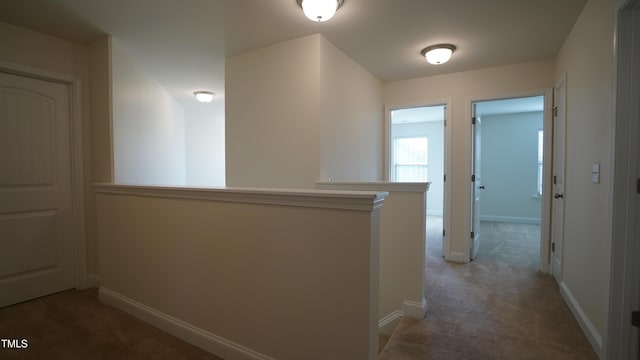 hallway featuring dark colored carpet