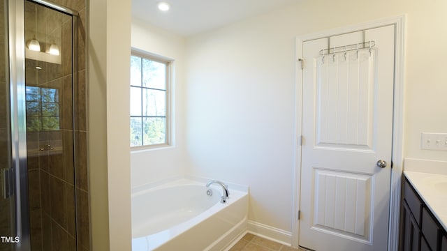 bathroom with tile patterned floors, vanity, and shower with separate bathtub