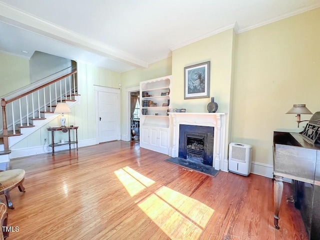 living room with hardwood / wood-style flooring, ornamental molding, and beam ceiling