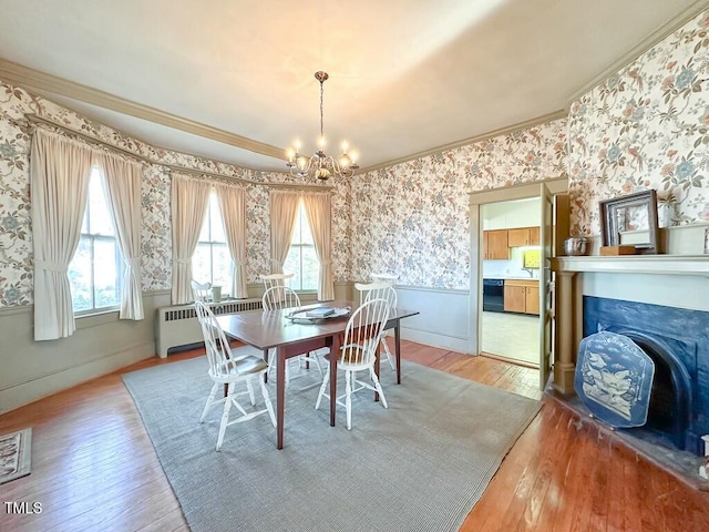 dining room featuring crown molding, radiator, hardwood / wood-style floors, and a notable chandelier