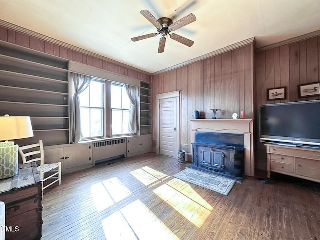 interior space featuring hardwood / wood-style flooring, crown molding, radiator heating unit, and ceiling fan