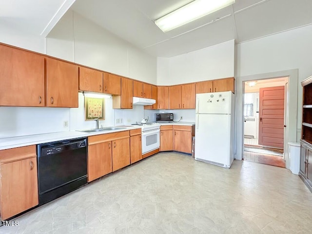 kitchen with sink, a towering ceiling, and black appliances