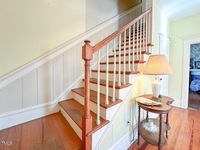 staircase featuring crown molding and wood-type flooring