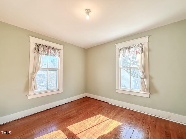 spare room with hardwood / wood-style flooring and plenty of natural light