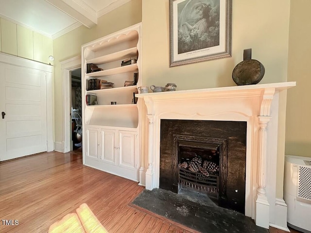 room details featuring beamed ceiling, ornamental molding, and hardwood / wood-style floors