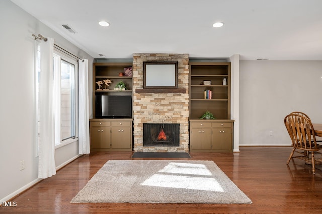 unfurnished living room featuring built in shelves, a fireplace, and dark hardwood / wood-style floors