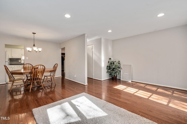 dining area featuring dark hardwood / wood-style flooring and a notable chandelier