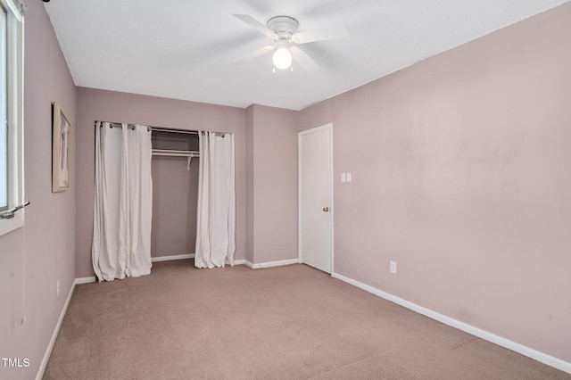 unfurnished bedroom with light colored carpet, a closet, and ceiling fan