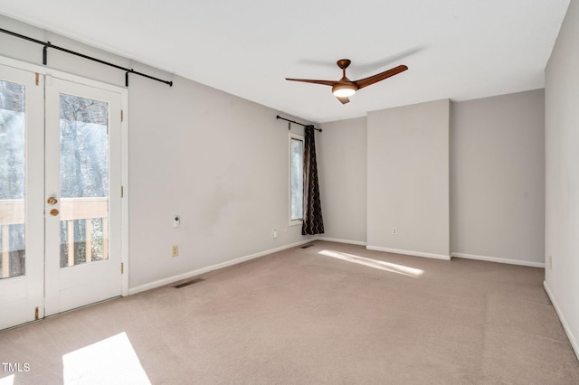 carpeted spare room with a healthy amount of sunlight and ceiling fan