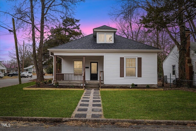 bungalow-style home featuring a porch and a yard