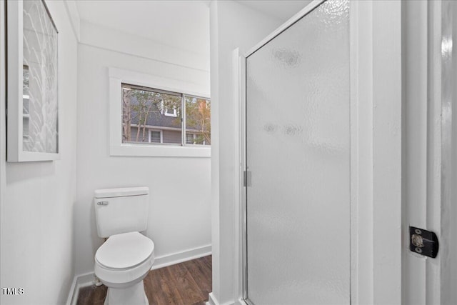 bathroom with toilet, a shower with door, and hardwood / wood-style floors