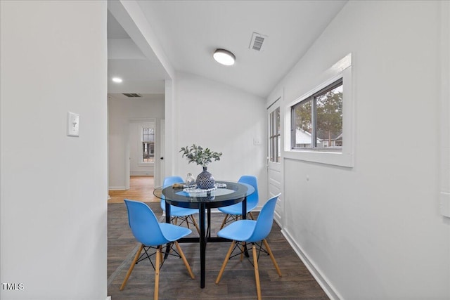 dining room featuring lofted ceiling, dark hardwood / wood-style flooring, and a wealth of natural light